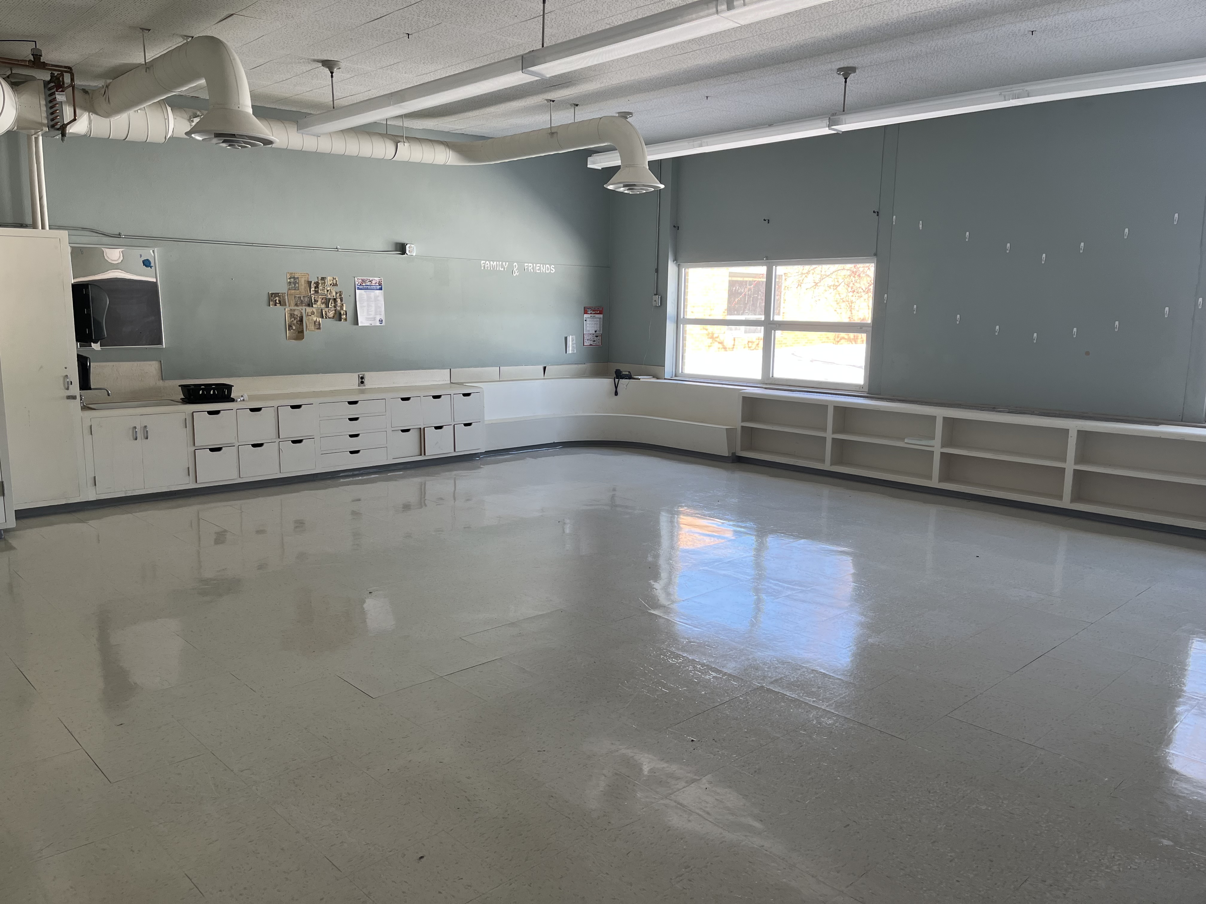 Art classroom with green walls and built-in cabinets